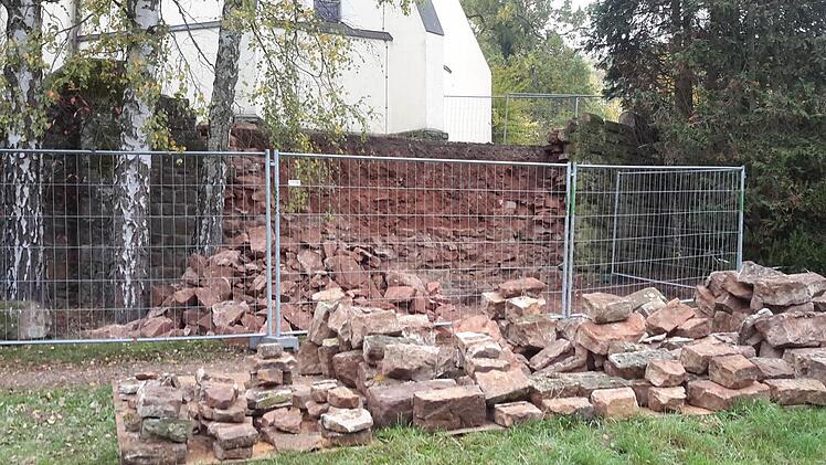 Ein Großteil der Steine der Kirchenmauer ist schon abgetragen und sortiert. Es wird momentan am Wegesrand gelagert. Das vorhandene Material soll später beim Aufmauern wiederverwertet werden.  Foto: Rolf Pralle