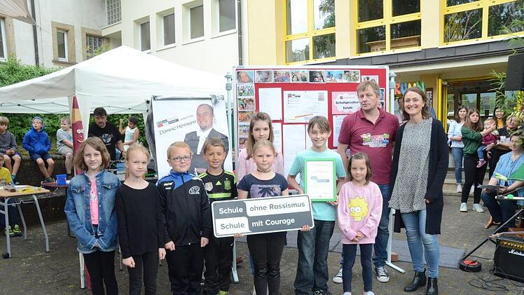 Große Freude in der Grundschule Weißenbrunn über die Aufnahme ins Netzwerk "Schule ohne Rassismus- Schule mit Courage". Mit im Bild Sabine Gerstner vom Bezirksjugendring Oberfranken (rechts) und Rektor Ralf Knöchel (2.von rechts). Im Hintergrund links ein Konterfei des Paten Dominic Herrmann. K.- H. Hofmann