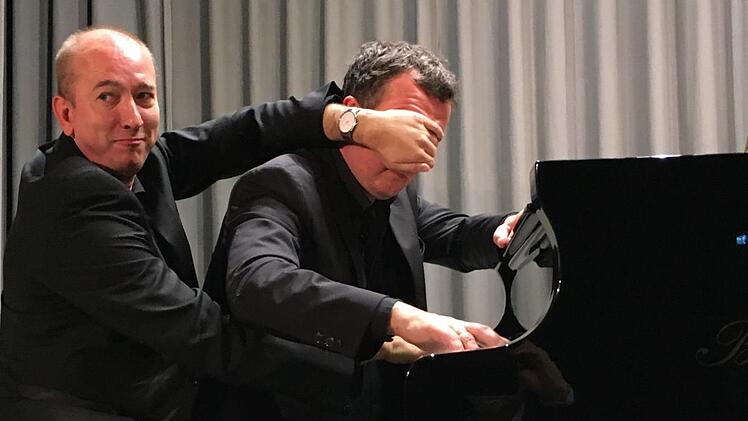 Immer zu Späßen aufgelegt: Beim vierhändigen Klavier-Spiel hält Chris Hopkins fürs Presse-Foto dem Pianisten Bernd Lhotzky die Augen zu. Foto: Ralf Ruppert