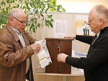 Albert Laudensack (links) tütet ein Handy ein. Nach Rücksprache mit Bürgermeister Helmut Blank sind im Rathaus und im Schloss Wahlurnen als Spendenboxen für alte Handys aufgestellt worden. Fotos: Thomas Malz