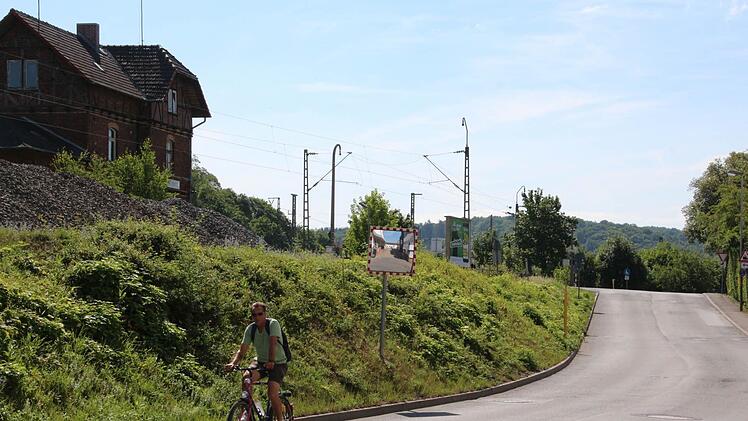 Noch führt am Creidlitzer Fabrikweg die Straße hinauf zum Bahnübergang. 2016 soll hier eine Unterführung gebaut werden.  Foto: Simone Bastian