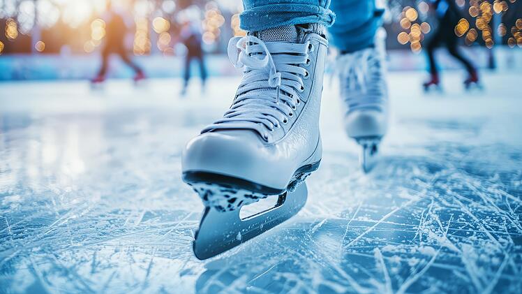 Close-up of a female skater's ice skate gliding on a sparkling rink.