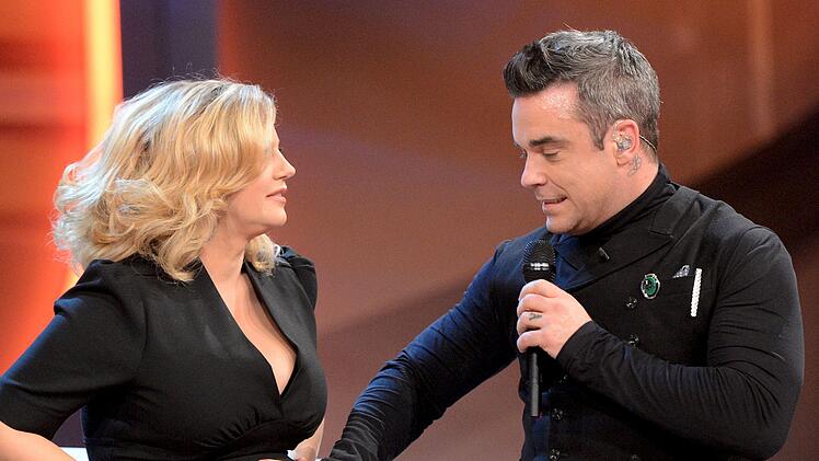 Bei "Wetten, dass..." wollte Robbie Williams 2012 unbedingt Schönebergers Babybauch anfassen. Bei der "Bambi"-Verleihung 2016 küsste er sie sogar.