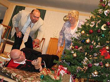 Schöne Bescherung: Werner (Hermann Zeis) und Babs (Silvia Klitzner) sind entsetzt, während Babs Ex-Mann Lutz (Mitte, Norbert Dietz) mitten in den Geschenken liegt. Foto: Gerda Völk