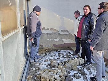 Hinter dem Buswartehäuschen hat Feuchtigkeit die Wand des Fridritter Feuerwehrgerätehauses stark in Mitleidenschaft gezogen. Unser Bild zeigt beim Ortstermin (von links) den Ortsbeauftragten und Stadtrat Jürgen Eckert, Feuerwehrkommandant Jürgen Frank, den Zweiten Bürgermeister Andreas Trägner  und Simon Glückert vom Bauamt. Foto: Dieter Britz