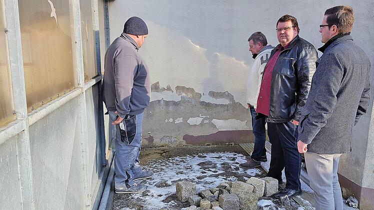 Hinter dem Buswartehäuschen hat Feuchtigkeit die Wand des Fridritter Feuerwehrgerätehauses stark in Mitleidenschaft gezogen. Unser Bild zeigt beim Ortstermin (von links) den Ortsbeauftragten und Stadtrat Jürgen Eckert, Feuerwehrkommandant Jürgen Frank, den Zweiten Bürgermeister Andreas Trägner  und Simon Glückert vom Bauamt. Foto: Dieter Britz