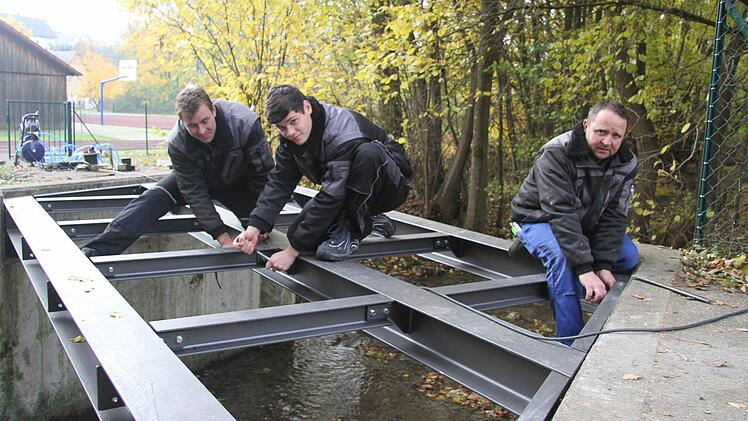 Die neue Brücke wird mit zwölf Gitterrosten belegt - jedes Gitterrost wiegt 80 Kilo. In nur einem Tag ist die neue Konstruktion fertig montiert: Daniel Vetter, Raphael Schimmel und Klaus Wollnik montieren die Maßanfertigung. Fotos: Sonja Adam