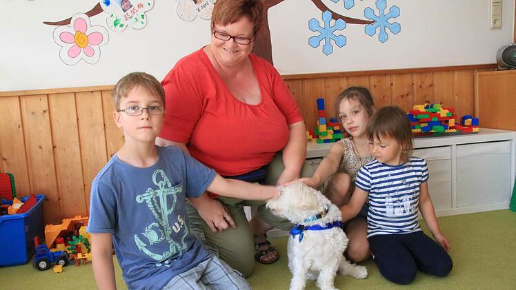 Brian, Valeria und Marlena finden gut, dass Bianca Müller ihren Hund Socke täglich in die Kita mitbringt.  Foto: Heike Beudert