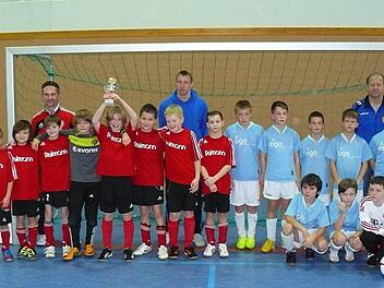 Hoch den Pokal. Die Jungs des FC Neuenmarkt (links) freuen sich über den Turniersieg bei den E 1-Junioren. Mit Platz zwei mussten die Spieler des Veranstalters FC Marktleugast (rechts) nach dem Siebenmeterschießen zufrieden geben. Fotos: Klaus-Peter Wulf