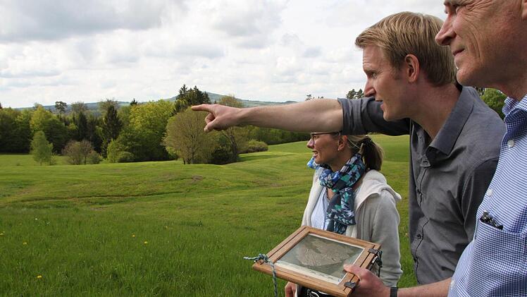 Unter dieser Wiese schlummert der Altort: Nils Ostermeier (Mitte) von der Uni Würzburg stellt das Ergebnis der archäologischen Untersuchung vor. Initiator Gerhard Morber und 2. Bürgermeisterin Beatrix Lieb können kaum fassen, dass die Funde so ein eindeutiges Bild zeichnen. Foto: Ulrike Müller