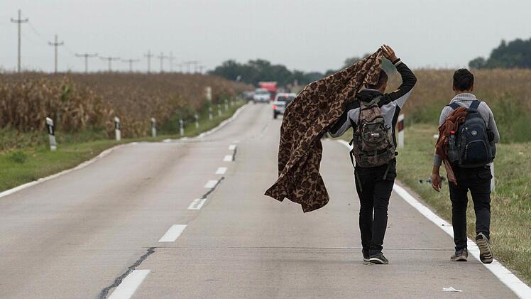 Flüchtlinge laufen von der serbischen Grenze in Richtung eines Zeltlagers bei Opatovac, Kroatien. Foto: Marijan Murat, dpa, Archiv