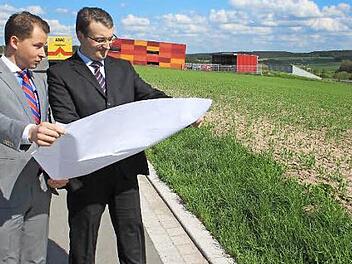 Vor einem Jahr stellten David Veit Krafft (links) und Matthias Gebhardt aus der Geschäftsleitung von Dennert Poraver am Bauplatz ihre Pläne für das neue Werk in Schlüsselfeld vor. Hier soll Blähglasgranulat produziert werden. Im Hintergrund die Firma Pröls und der ADAC Foto: Archiv