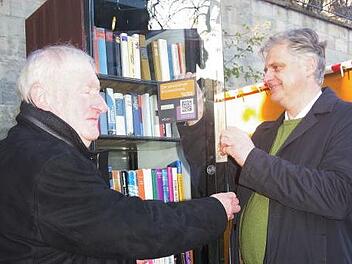 Hans-Jürgen Greve (rechts) bringt im Beisein von Lions-Freund Ulrich Strempel den QR-Code am offenen Bücherschrank an. Foto: Heike Scghülein