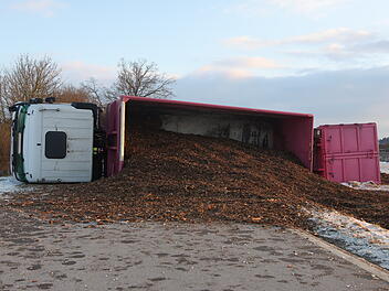 Lastwagen kommt von Stra&szlig;e ab und kippt um: Rindenmulch auf der Stra&szlig;e verteilt - Fahrer verletzt