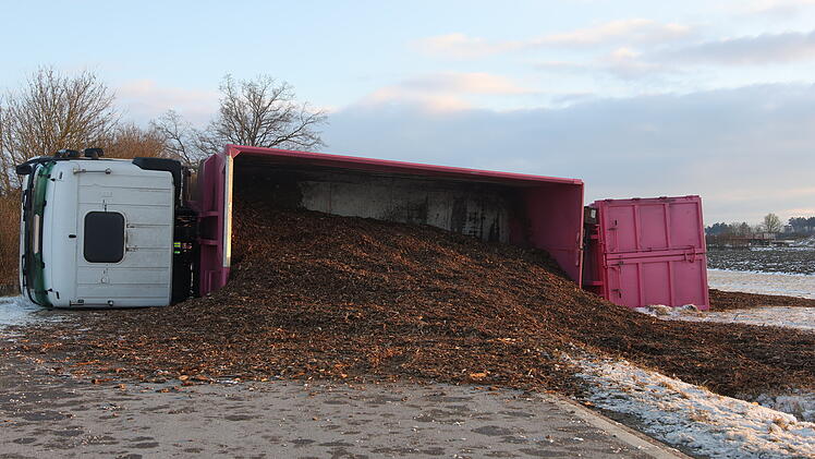 Lastwagen kommt von Stra&szlig;e ab und kippt um: Rindenmulch auf der Stra&szlig;e verteilt - Fahrer verletzt