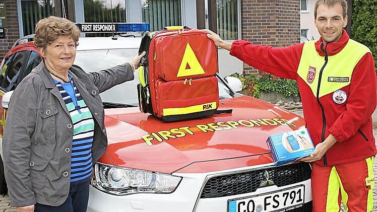 Renate Mannel (links) übergibt den neuen Einsatzrucksack und ein Pulsoxymeter an den neuen Leiter der First Responder Untersiemau, Gabriel Schrader.  Foto: Michael Stelzner