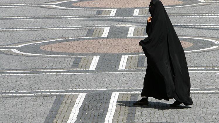 In M&uuml;nchen: Eine Frau in einer Burka geht &uuml;ber den Odeonsplatz. Foto: Frank Leonhardt, dpa