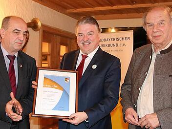 Den Verbandsorden in Silber verlieh der Bezirksvorsitzende des Nordbayerischen Musikbunds, Thomas Kolb (links), an Landrat Klaus Peter Söllner. Rechts Kreisvorsitzender Heinrich Ramming Foto: Klaus Klaschka
