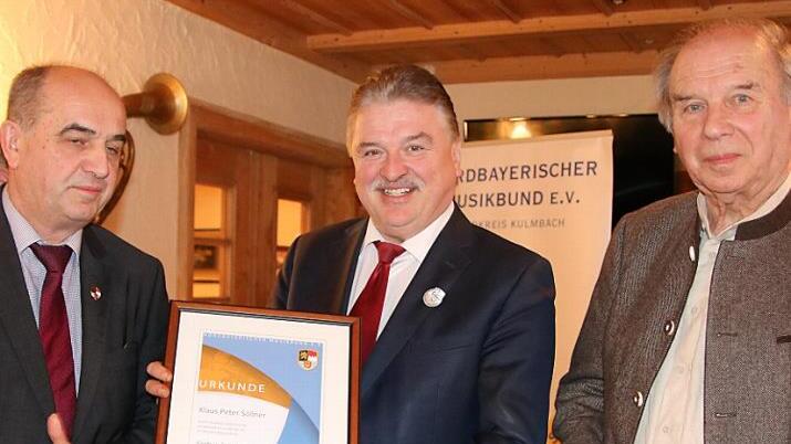 Den Verbandsorden in Silber verlieh der Bezirksvorsitzende des Nordbayerischen Musikbunds, Thomas Kolb (links), an Landrat Klaus Peter Söllner. Rechts Kreisvorsitzender Heinrich Ramming Foto: Klaus Klaschka