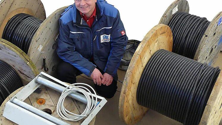 Gerald Gräf von der ÜZ zwischen Kabeln, die in Wiesentheid und Umgebung noch in die Erde müssen - auch das kostet Geld, das auf den Stromkunden umgelegt werden muss.  Foto: Karina Brock
