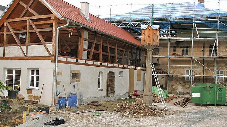 Links gut zuerkennen der bereits sanierte ehemalige Kuhstall, rechts das alte Hauptgebäude, das noch arbeitsintensive Jahre fordert. Im Moment ist der Dachstuhl dran. Fotos: Bertram Wagner
