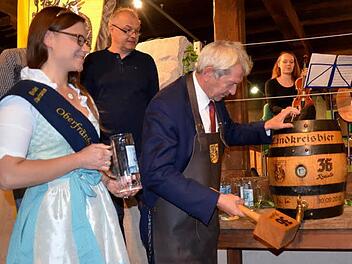 Unter den Augen der Oberfränkischen Bierkönigin Christina Pollnick sticht Landrat Johann Kalb ein Bierfaß mit "36 Kreisla - Fränkisch Hell" an. Foto: Andrea Spörlein