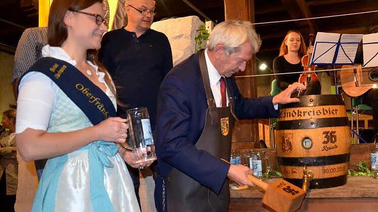 Unter den Augen der Oberfränkischen Bierkönigin Christina Pollnick sticht Landrat Johann Kalb ein Bierfaß mit "36 Kreisla - Fränkisch Hell" an. Foto: Andrea Spörlein