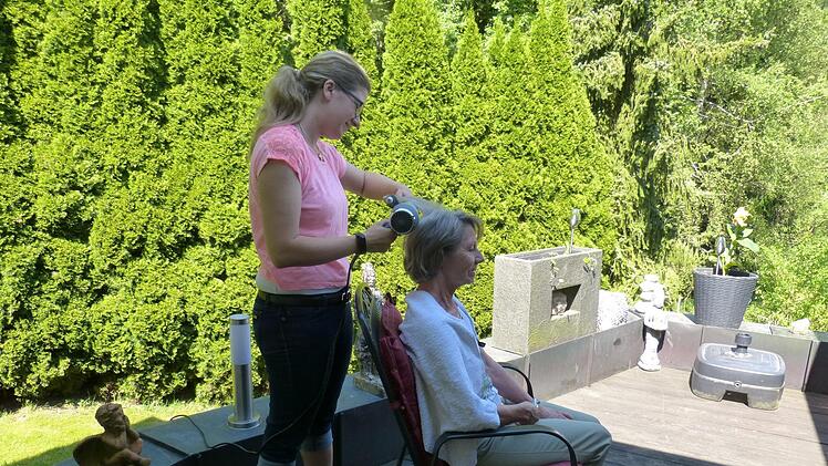 Melanie Pfeufer frisiert eine Kundin zu Hause. Foto: Carmen Schwind
