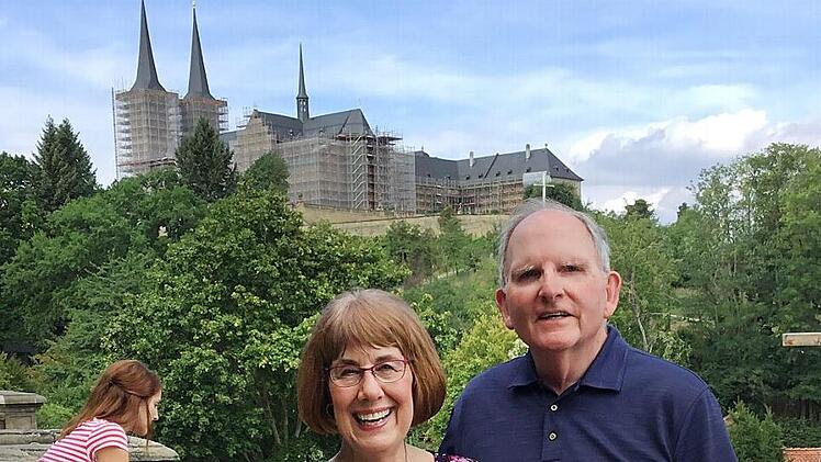 Trudy und Pat Elsberry im Rosengarten mit Blick auf St. Michael Foto: Hanns Steinhorst