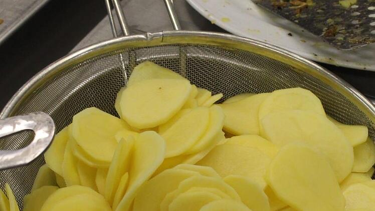 Aus rohen Kartoffelscheiben wird das Gratin zubereitet.