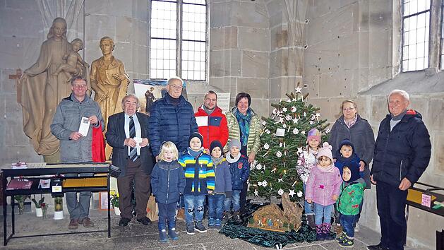 Auch heuer schm&uuml;ckten Kinder der Rosenberg-Kita den Christbaum in der St.-Anna-Kapelle. Gemeinsam mit den Hauptorganisatoren Werner M&uuml;ller (Dritter von links), Lukas L&ouml;ffler (Vierter von links), Siegfried Schneider (rechts) sowie (von links) KEB-Gesch&auml;ftsf&uuml;hrer Stephan Renczes und KEB-Vorsitzender Heinz Hausmann laden sie zum Krippen-Spaziergang ein.