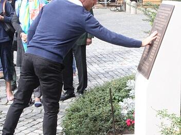 Der Historiker Mark Deavin benetzt das Mahnmal mit Wasser. Die Symbolik des "Taufwassers" auf diesem Stein konnte von allen Besuchern vollzogen werden.  Fotos: Michael Busch