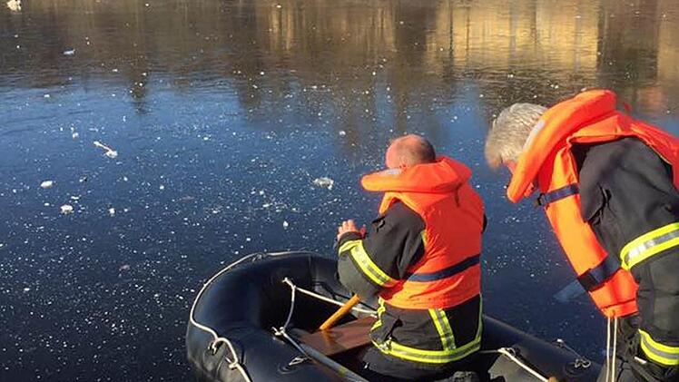 Die Feuerwehr rückte mit einem Schlauchboot übers Eis vor, um den Vogel zu befreien.
