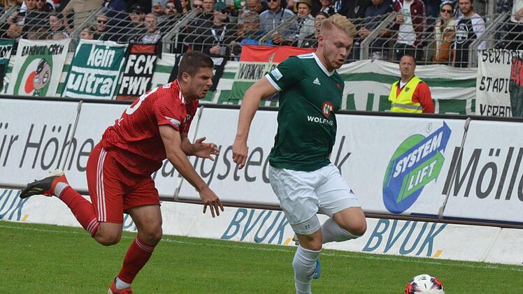 Mehr Kampf als Spiel: Der Schweinfurter Stefan Maderer (gr&uuml;n) m&uuml;ht sich zwar am Memminger Lirim Kelmendi vorbei, eine Anspielstation findet er danach aber nicht.  Foto: Marion Wetterich