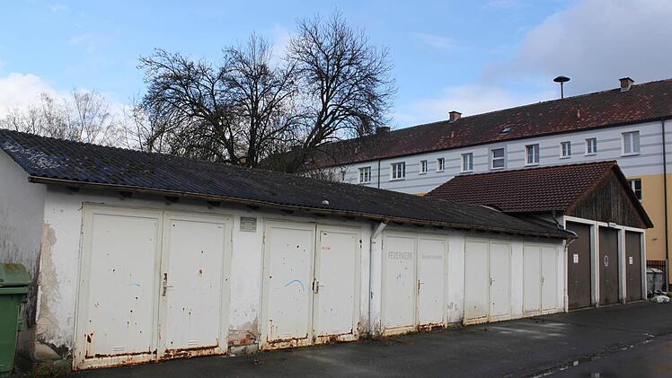 An die Stelle des linken Garagengebäudes in der Eichendorff-Siedlung soll bis nächsten Winter ein Blockheizkraftwerk entstehen. Im Hintergrund sieht man ein Gebäude in der Wachtersflur, dessen Fassade bereits saniert wurde.