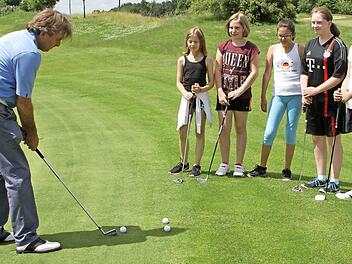 Ganz genau beobachten die Mädchen, wie ihnen Jamie Ballantyne (links) den Putt zum Einlochen zeigt. Foto: Günther Geiling