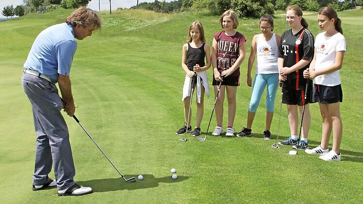 Ganz genau beobachten die Mädchen, wie ihnen Jamie Ballantyne (links) den Putt zum Einlochen zeigt. Foto: Günther Geiling