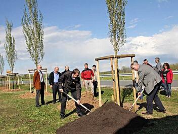 Bevor Alfons Schanz und Bürgermeister Helmut Dietz (vorne von links) letzte Hand bei der Pflanzaktion anlegten, wurde mit den Bürgerinnen und Bürger ausgiebig wegen der Fällaktion der alten Pappel diskutiert.  Foto: Helmut Will
