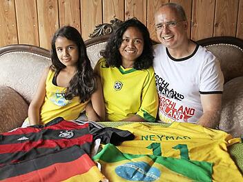 Deutschland- und Neymar-Trikot wie die Fahnen beider Heimatländer liegen bereit: Iris, Valdinez und Oliver Dünisch (von links) stehen für deutsch-brasilianische Freundschaft, aber auch fußballerische Konkurrenz.