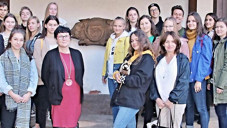 Das Wappentier der Stadt Ebern, von Bürgermeister Jürgen Hennemann (links) bei seiner Begrüßung erklärt, musste mit auf das Gruppenfoto der munteren Schülerschar. Mit auf dem Bild sind außerdem die Direktorin der Schule in Zory, Ursula Machakca (vorne, Dritte von links), die Deutschlehrerin Barbara Barglik (vorne, rechts) und der Schulleiter des Friedrich-Rückert-Gymnasiums Ebern, Oberstudiendirektor Martin Pöhner (Zweiter von rechts). Foto: Helmut Will