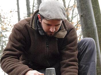 Philipp Schinkel versenkt einen der für die Untersuchungen wichtigen Markierungsstifte im Waldboden.