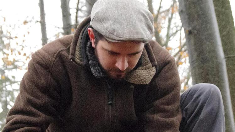 Philipp Schinkel versenkt einen der für die Untersuchungen wichtigen Markierungsstifte im Waldboden.