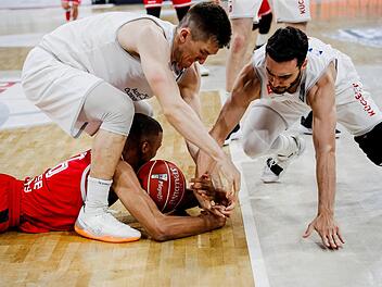 In den Play-offs wird noch verbissener um den Ball gekämpft als sonst. Hier wirft sich der Bamberger Louis Olinde nach dem Spielgerät, das ihm die Vechta-Spieler T. J. Bray und Max DiLeo (rechts) wieder abnehmen wollen. Foto: Daniel Löb