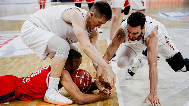 In den Play-offs wird noch verbissener um den Ball gekämpft als sonst. Hier wirft sich der Bamberger Louis Olinde nach dem Spielgerät, das ihm die Vechta-Spieler T. J. Bray und Max DiLeo (rechts) wieder abnehmen wollen. Foto: Daniel Löb