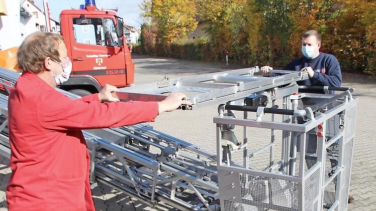 Gerätewart Johannes Tohol (links) und Kommandant Benjamin Obexer montieren auf dem Rettungskorb das Gestell für die Trage.