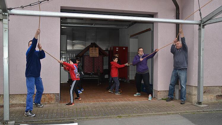 Beim Zeltaufbau für das Katzenbacher Backofenfest helfen auch die ganz jungen Nachwuchsmusiker mit. Hier ziehen sie vor der Küche die Dachplane in Position. Foto: Kathrin Kupka-Hahn