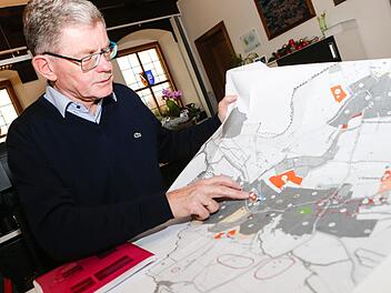 Bürgermeister Wolfgang Möhrlein zeigt auf einem Flächennutzungsplan, welche ursprünglich geplanten Baugebiete der Ortsteile Litzendorf, Naisa und Pödeldorf wieder gestrichen wurden. Stattdessen setzt die Gemeinde auf Innenentwicklung. Foto: Matthias Hoch