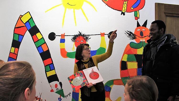 Claudia Körber erklärt die Figuren an der Wand anhand des Buches "rund und eckig" der Kinderbuchillustratorin Kveta Pacovská.  Fotos: Julia Raab
