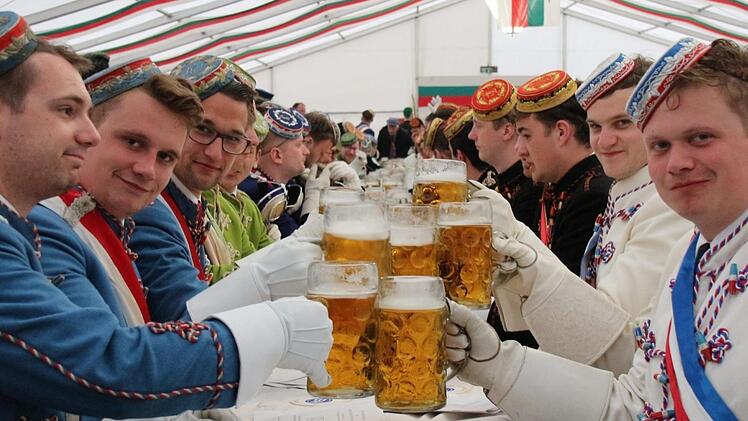 Normalerweise ziehen die Chargierten mit ihren bunten Uniformen zu Beginn des Festkommers ins Zelt ein. Diesmal saßen sie schon vorher drin - die schweren Uniformjacken sollten nicht nass werden. Foto: Simone Bastian