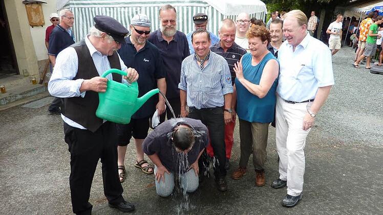 Genüsslich nahm Vorsitzender Friedrich Fricke die Flößertaufe mit Rodachwasser bei Kreiskulturreferentin Gisela Lang vor.  Foto: Gerd Fleischmann